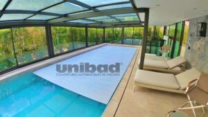 Piscine intérieure en toit terrasse équipée d’un volet automatique de piscine Unibad en fond de piscine